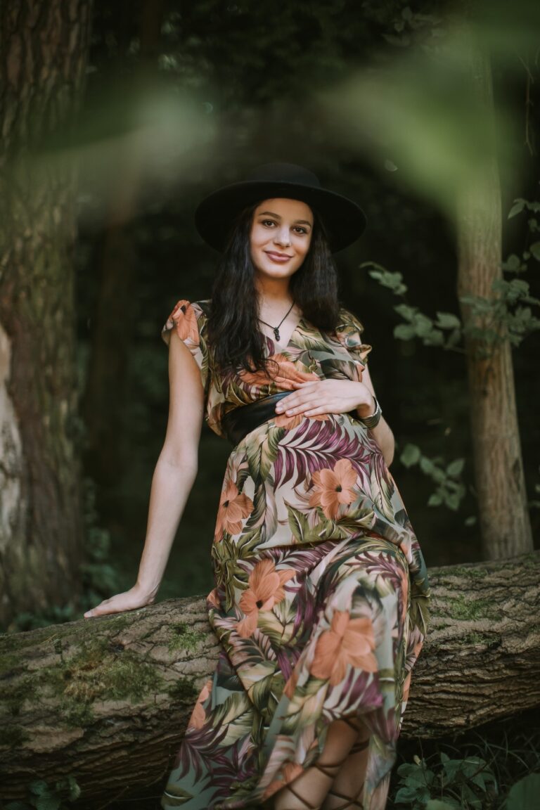 Pregnant likable Caucasian woman 25-30 year old posing outdoors in beautiful forest